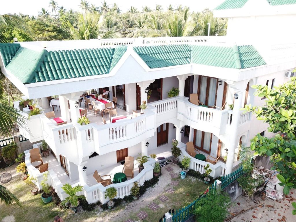 The Beach House colonial-style hotel surrounded by palms