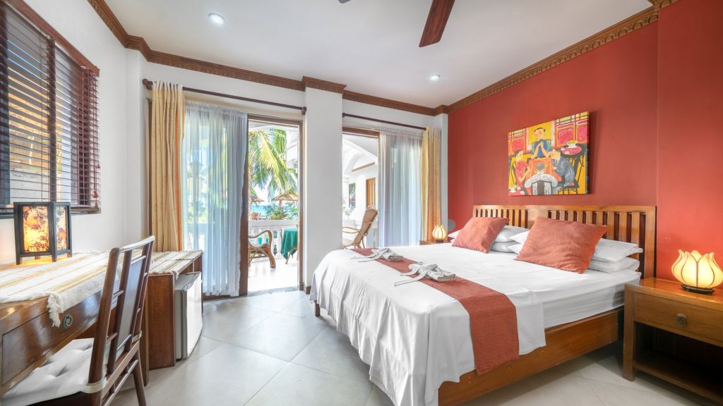 A Premier room with a queen bed and balcony doors