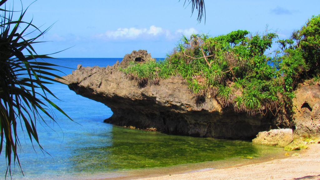 A rocky islet in clear blue water