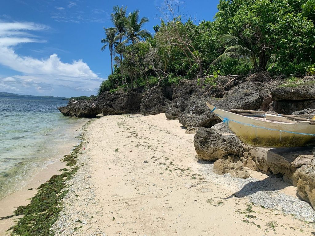 A white coral beach below green hills