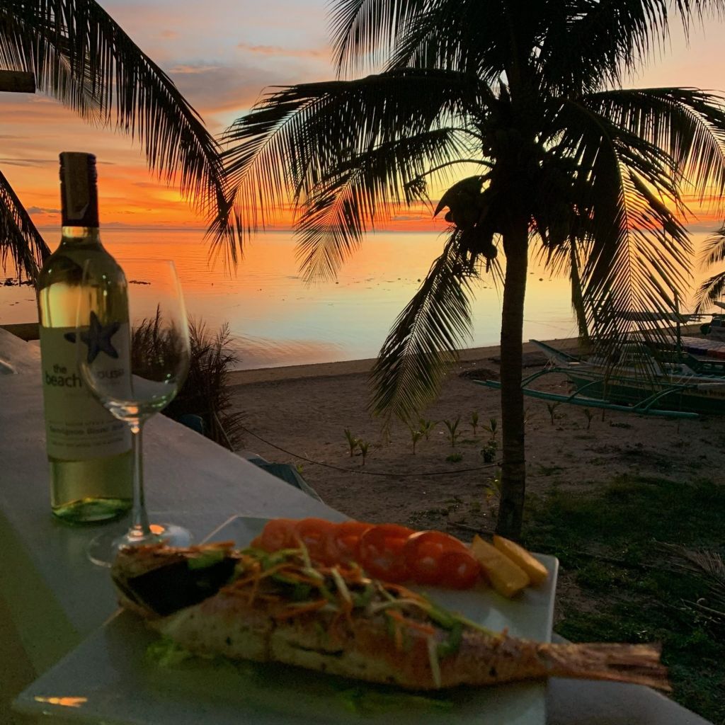White wine and dinner on the beach at sunset