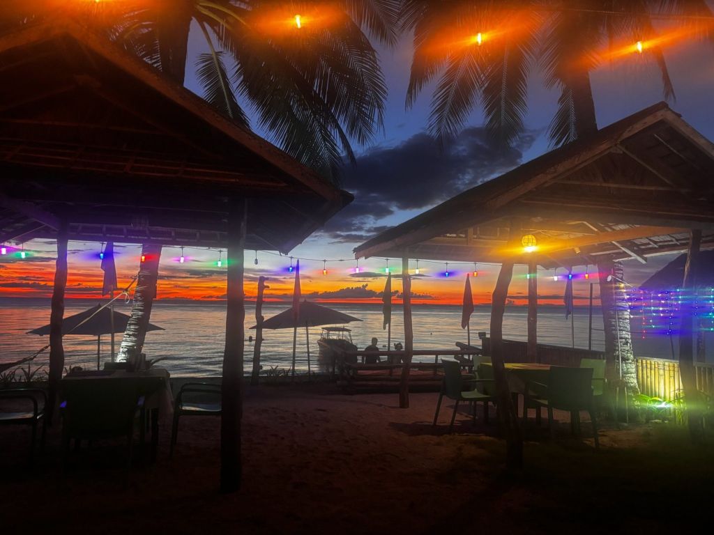 The beach restaurant lit up at dusk
