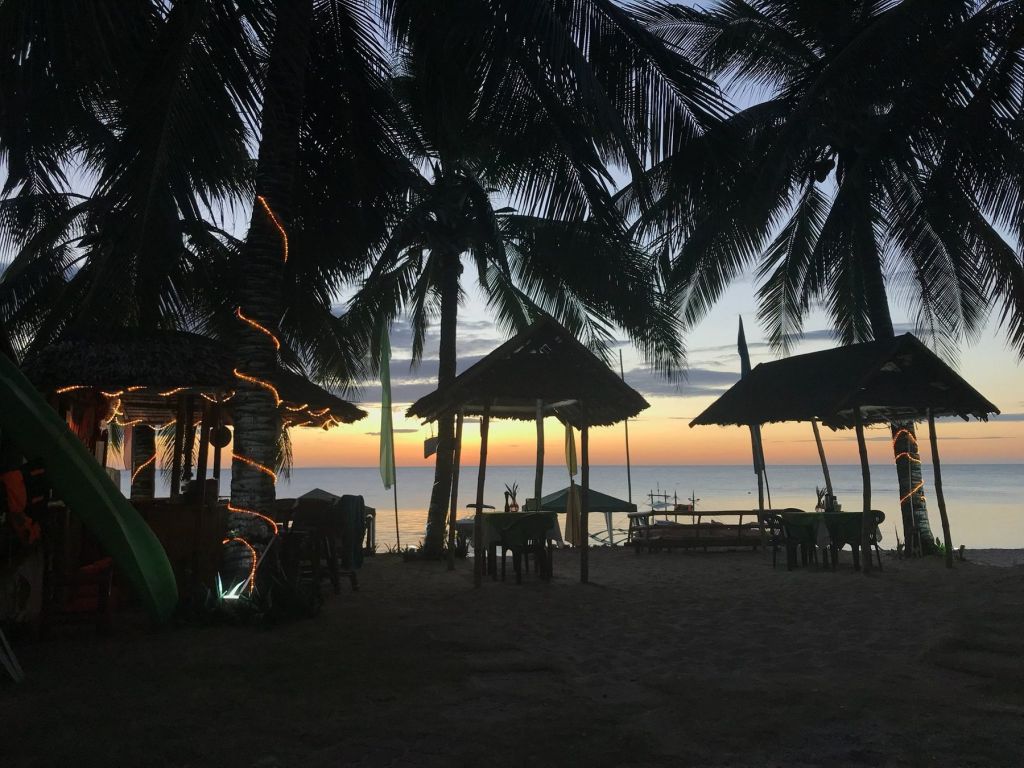 Beach huts silhouetted against the sunset
