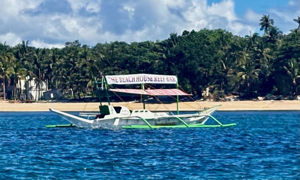 The Beach House bangka on blue water