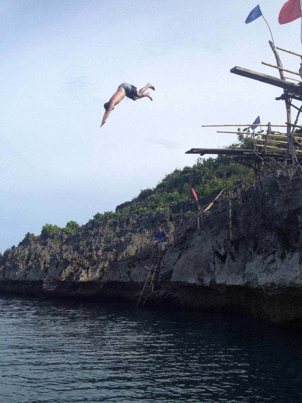 A guest jumping from a cliff platform into the sea