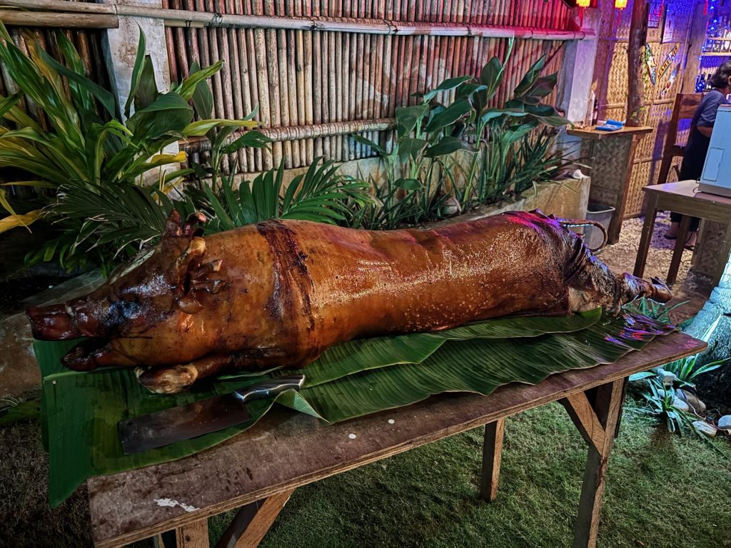 A whole lechon, spit-roast pig, served on banana leaves