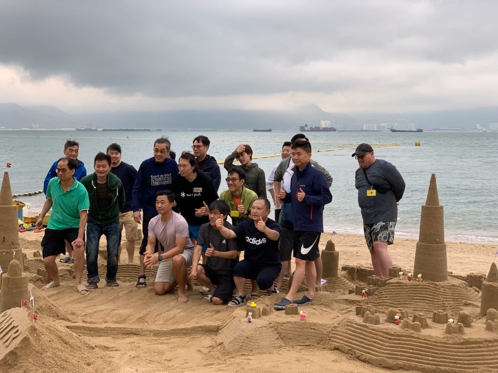A team with their sandcastle on the beach