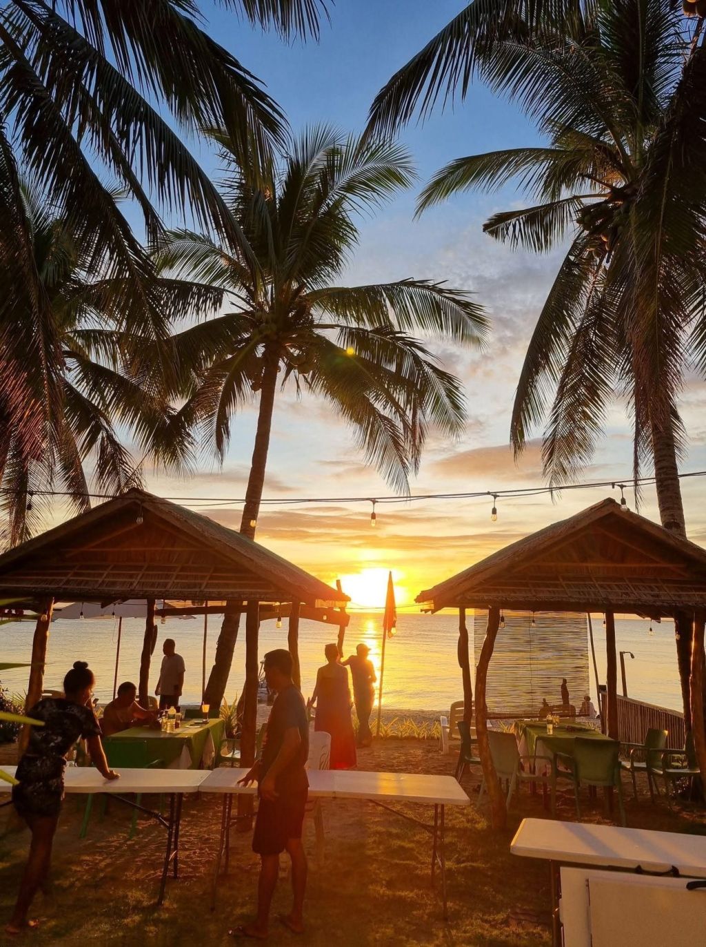The sun setting between the beach huts