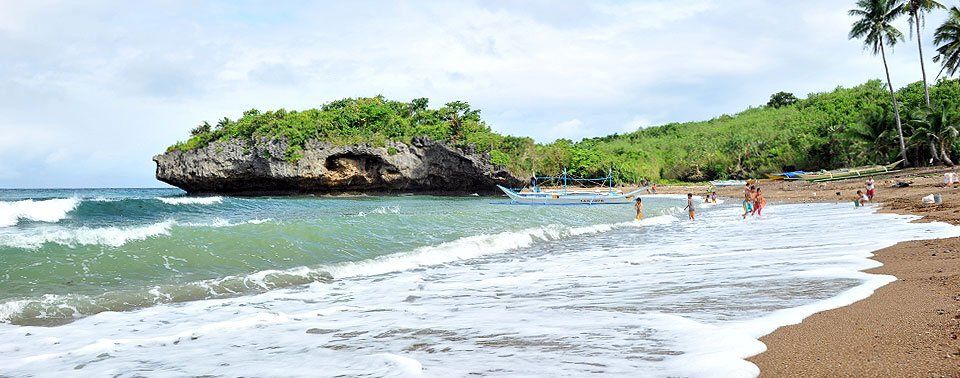 A rocky islet off a sandy beach