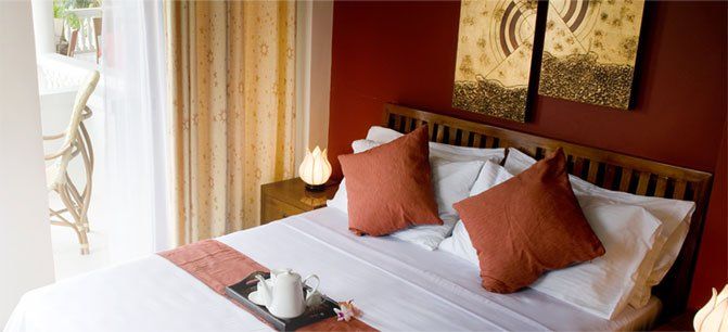 Bedroom with red accent wall and orange cushions